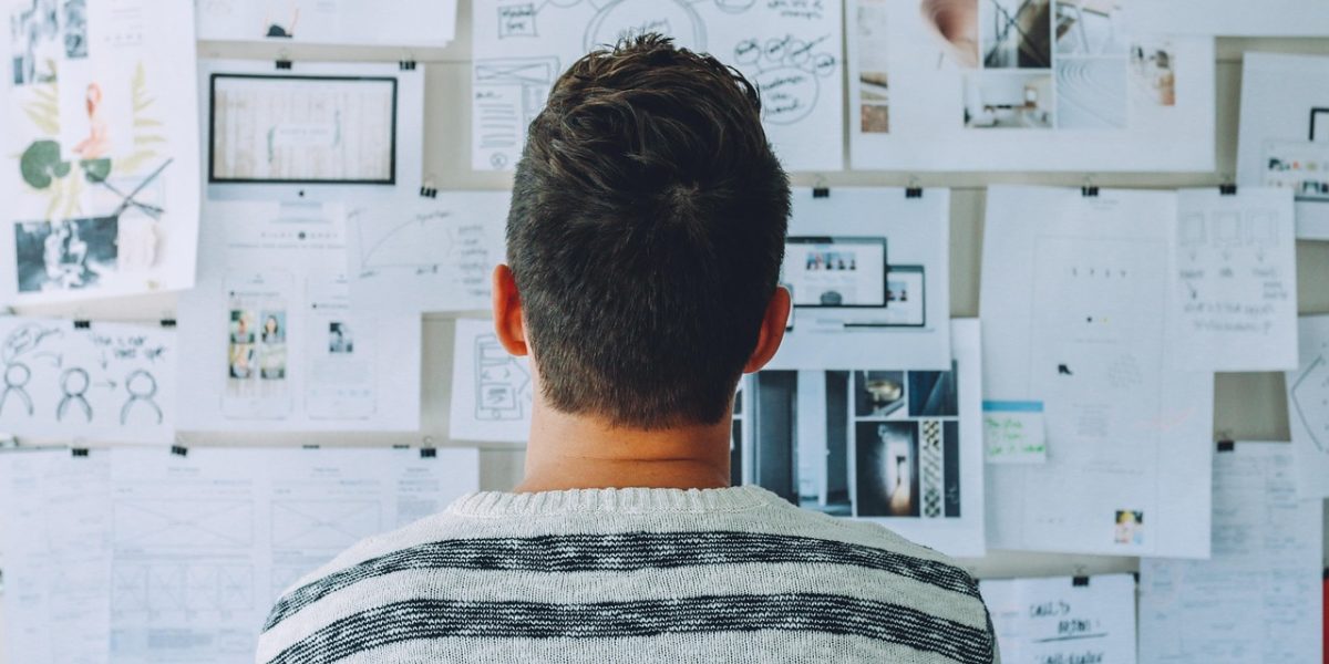 A person looking confidently at a whiteboard, planning for future trends and strategic growth.