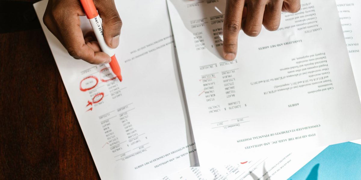 A person intently reviews financial documents and calculations, focusing on comprehensive costs.