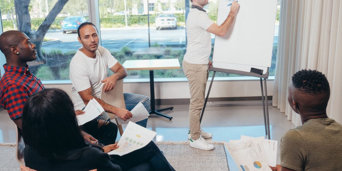 A diverse team collaborating on a whiteboard, reflecting the collective intelligence at industry events.