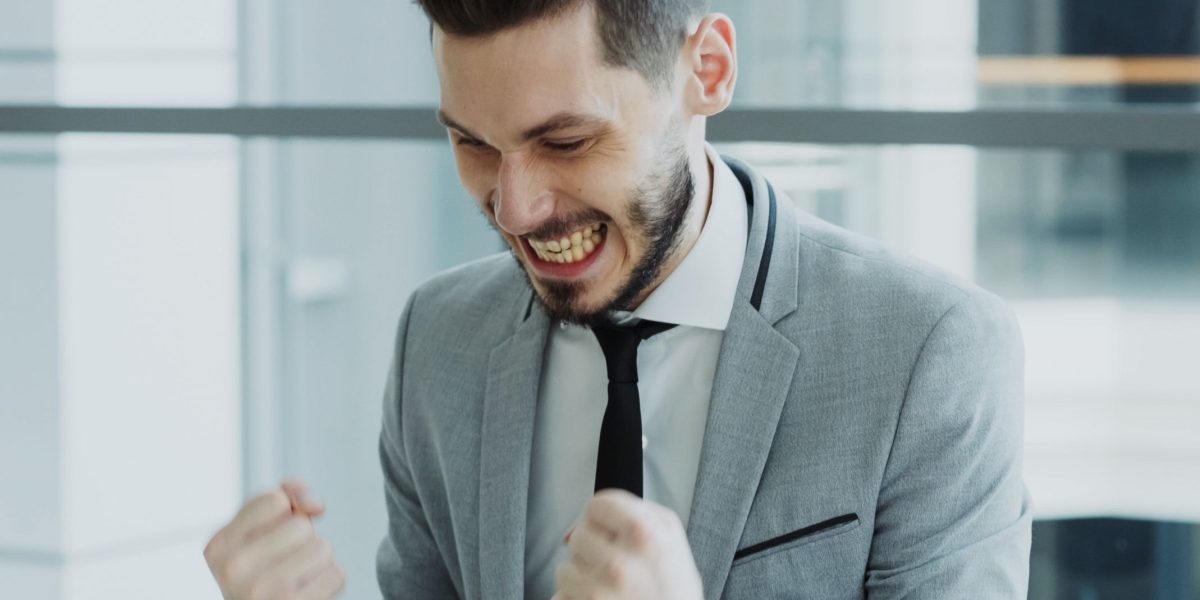 A person celebrating a business achievement, representing the high ROI and success possible with email marketing.