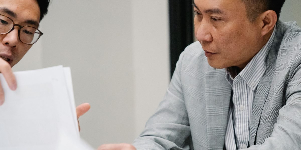 Two business professionals meticulously reviewing documents and data, embodying the due diligence process for partner selection.