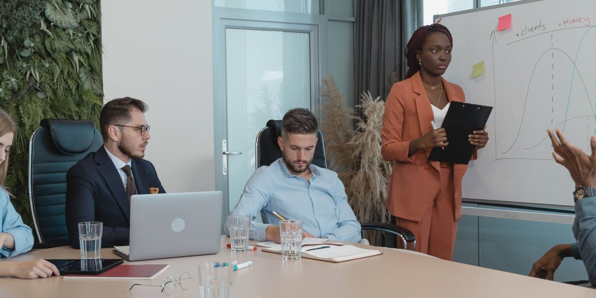 A diverse team collaborating around a whiteboard, discussing and planning a marketing strategy.