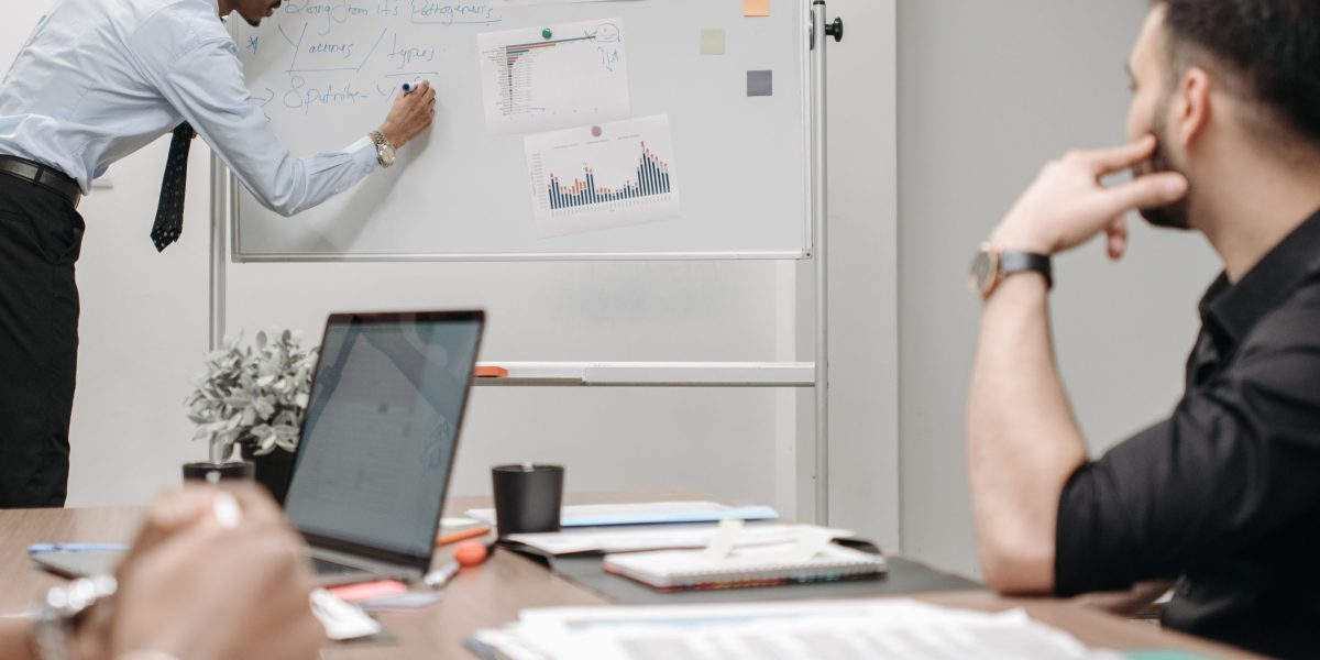 A team evaluates different marketing strategies, weighing the pros and cons of in-house vs. agency partnerships.