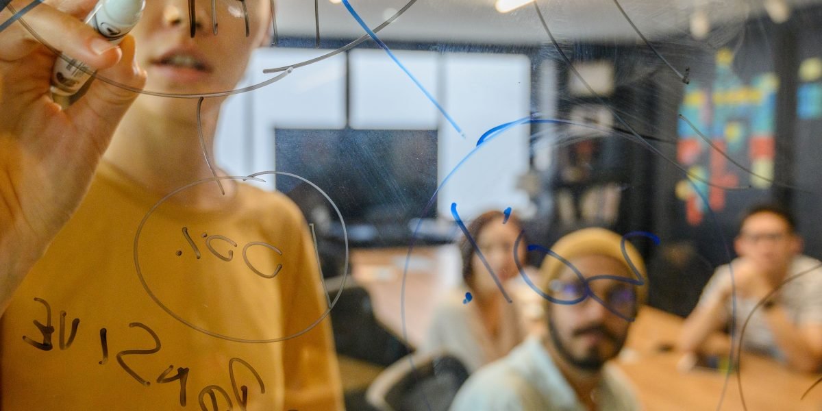 A diverse team collaborating on innovative ad creatives, leveraging AI tools for optimization and testing.