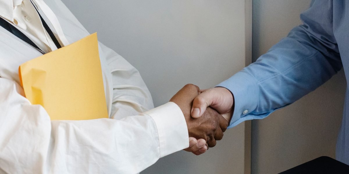 Two business professionals shaking hands, symbolizing trust and strong relationships in a professional context.