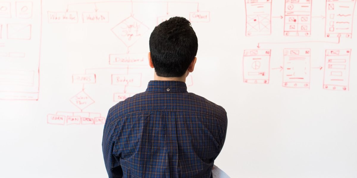 A diverse team collaborating, pointing at a whiteboard, representing the process of evaluating software options.