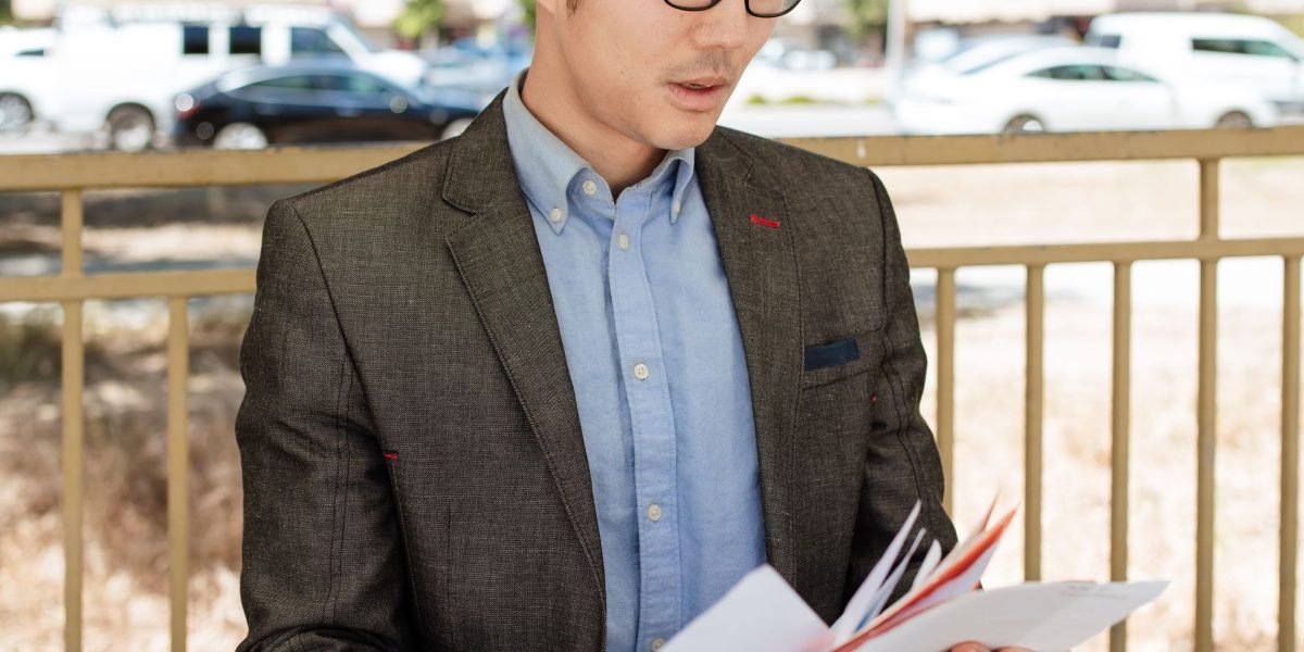 An individual thoughtfully reviewing documents, assessing past advertising performance and identifying areas for improvement.