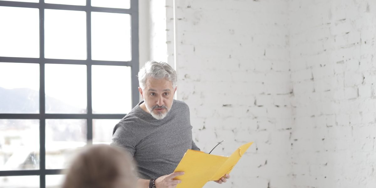 Professionals in a meeting, one explaining documents to another, symbolizing a client consultation.